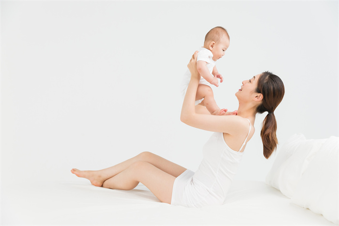 攝圖網_500962365_母嬰床上媽媽舉起寶寶（企業(yè)商用）.jpg